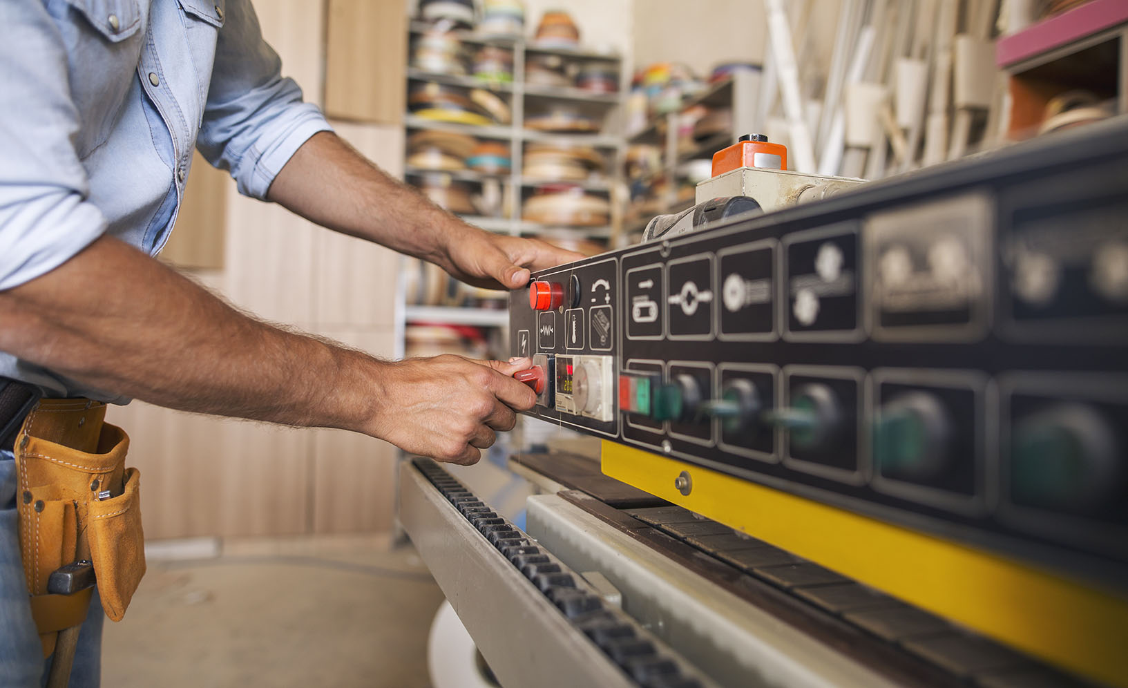 Male hands adjusting buttons on woodworking machine